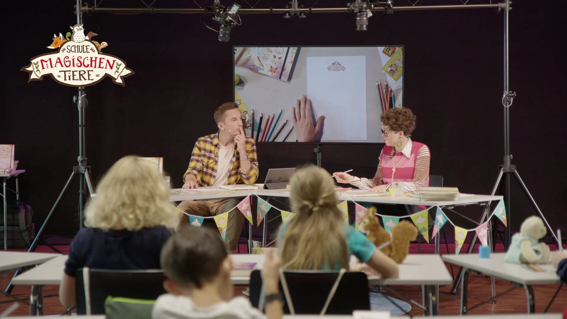 Zwei Personen sitzen vor einem Bildschirm 