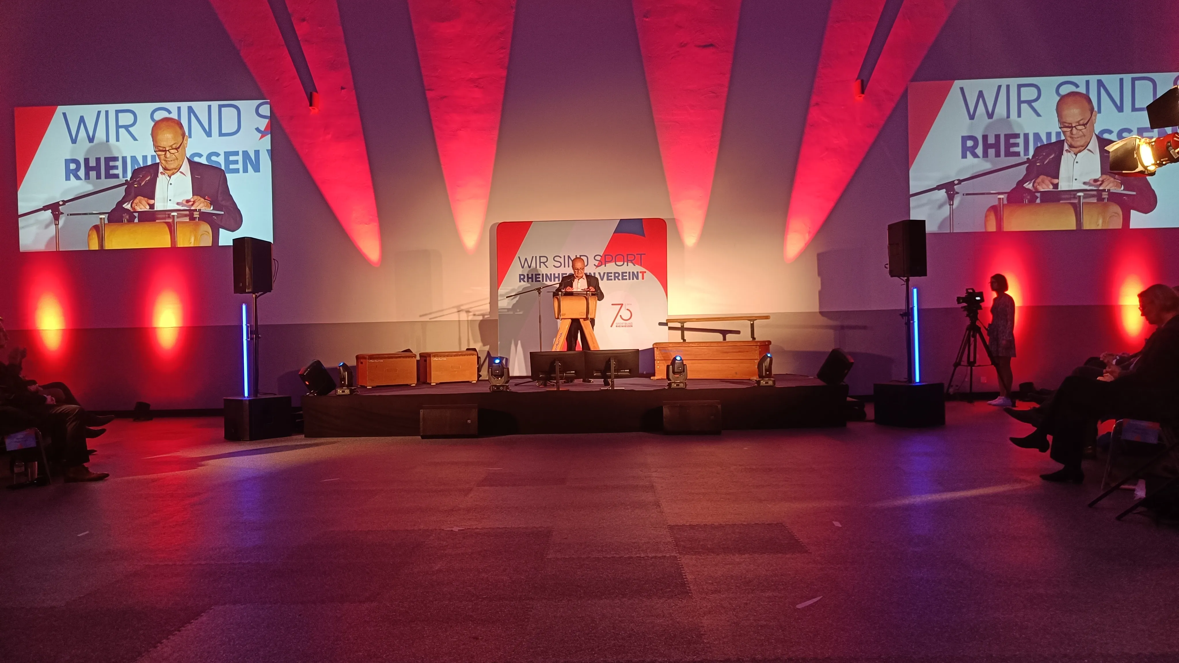 Bühne, auf der ein Mann eine Rede hält